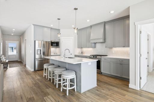 Spacious island with seating for four, highlighted by elegant pendant lighting