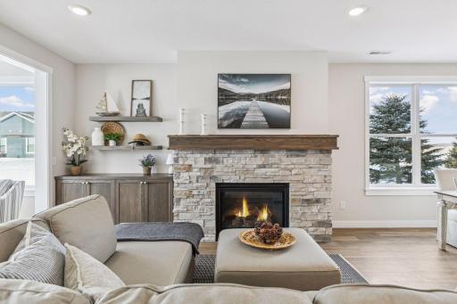 Gorgeous stone gas fireplace with built-in cabinetry and floating shelves