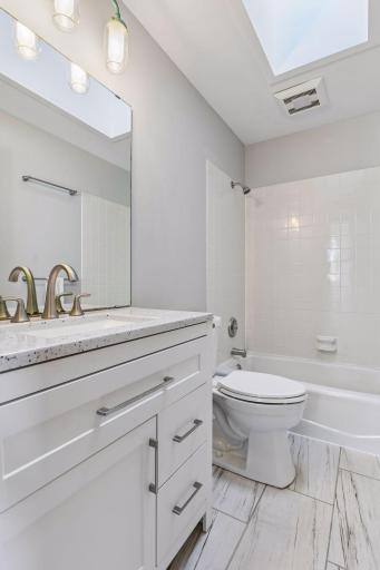 Upper level bathroom was recently updated with new flooring, vanity, lighting, and tile regrouted
