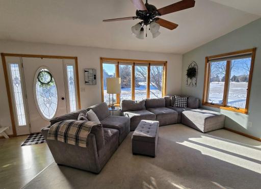 Living room has vaulted ceiling, plenty of natural sunlight & ceiling fan.