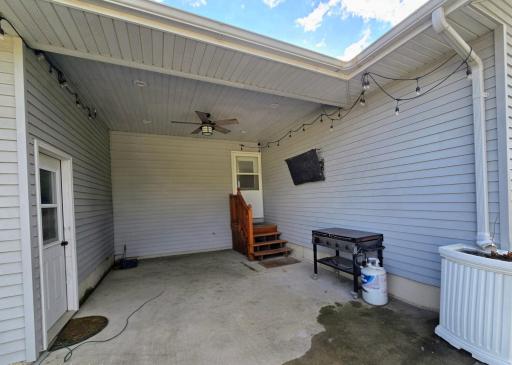 Covered patio area with outdoor tv & access to garage