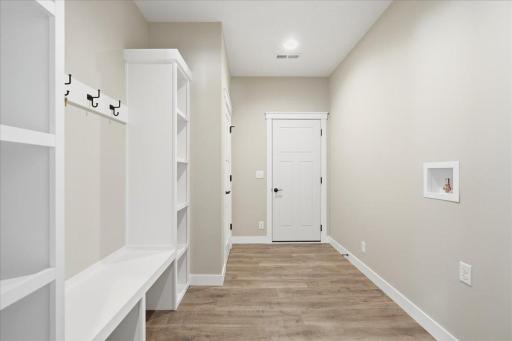 Mudroom / laundry room with built-in bench and shelving