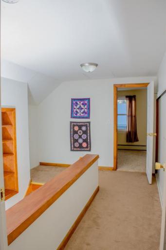 Landing area with built-in shelving and access to adjacent rooms.