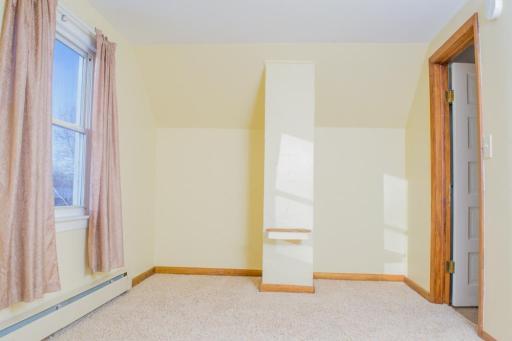 Additional view of the upper-level bedroom showing wall layout and usable floor space.