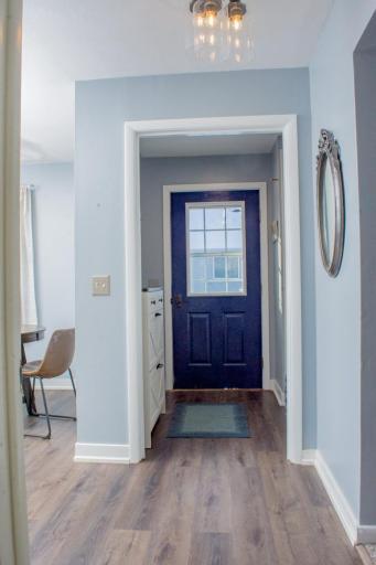 Additional view of the rear entry showing exterior door access and surrounding wall space for storage.