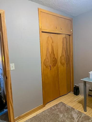 Bedroom storage featuring wood sliding closet doors with upper cabinet space.