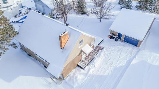 Overhead winter view showing the home, rear deck, detached garage, and driveway layout.