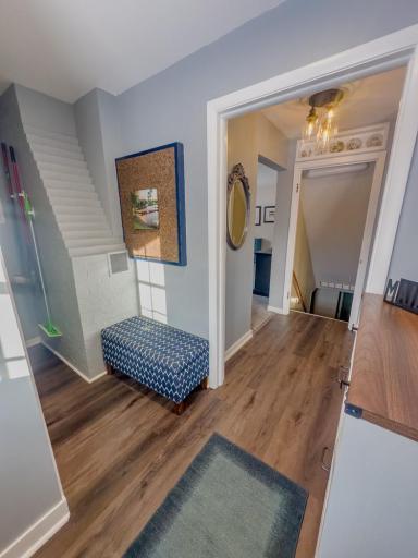 Hallway area with durable flooring, built-in bench space, and access to stairs and adjacent rooms.