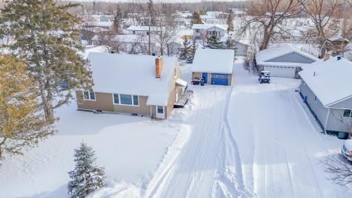 9. **Aerial View (Winter)** – Aerial perspective showing the home, detached garage, driveway layout, and neighboring properties.