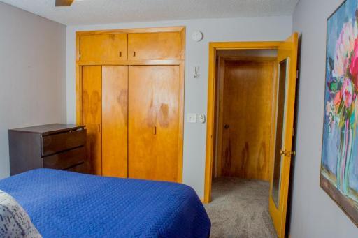 Bedroom view showing built-in closet storage and access to adjacent hallway.