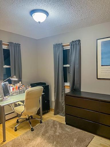 Flexible bedroom area with windows for natural light and room for a desk or storage pieces.