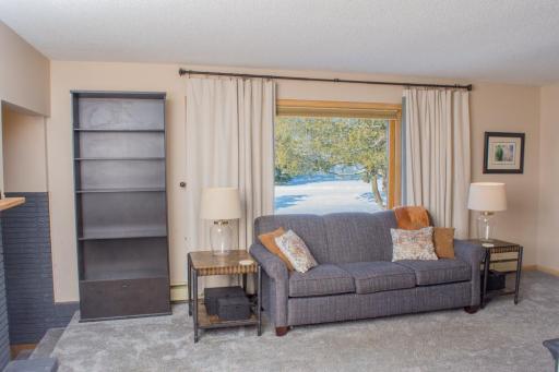 Living room view with large window providing natural light and flexible furniture layout.
