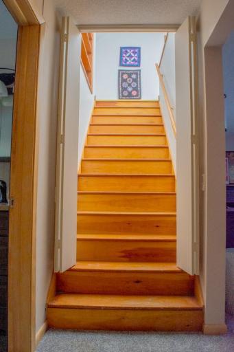Staircase leading to the upper level with wood steps and handrail.
