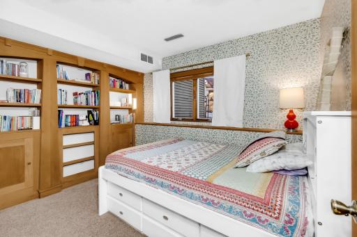 lower level bedroom with built in wall unit and daylight window