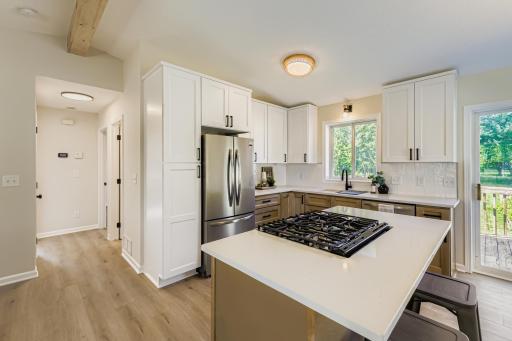 Stylish two-tone, soft-close cabinetry, and Frigidaire stainless steel appliances in a functional open layout.