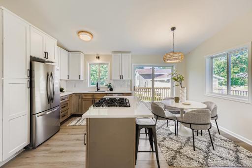 Bright and open kitchen with quartz countertops, gas cooktop, and island seating.