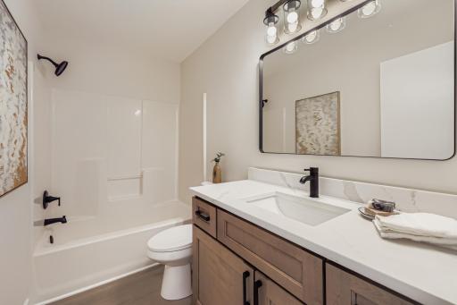 Upper-level full bath with soft-close vanity, matte black fixtures, and modern lighting.