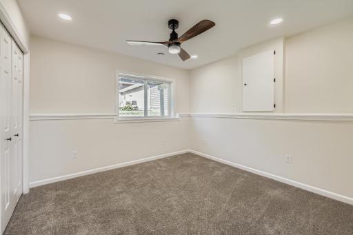 Lower-level bedroom with recessed lighting and remote-controlled ceiling fan.