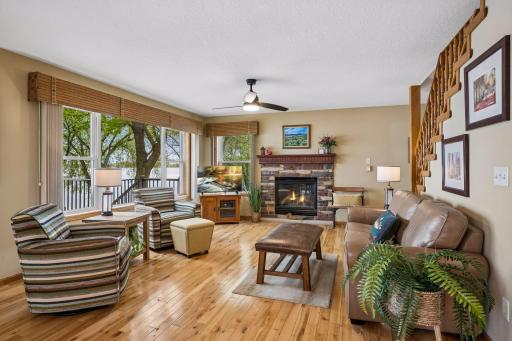 The living room features rich hardwood floors, a cozy gas fireplace, and beautiful Lake Miltona views.