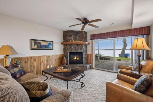 Inviting lower-level family room with stone gas fireplace and walk-out access to the lakeside patio.