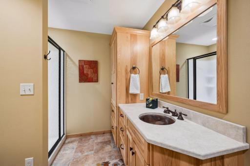 Lower level 3/4 bath features abundant custom cabinetry, generous counter space, and a walk-in shower.