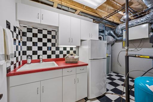 The utility and storage area includes built-in cabinetry, sink, and refrigerator. This is a perfect space for lake life organization and convenience.