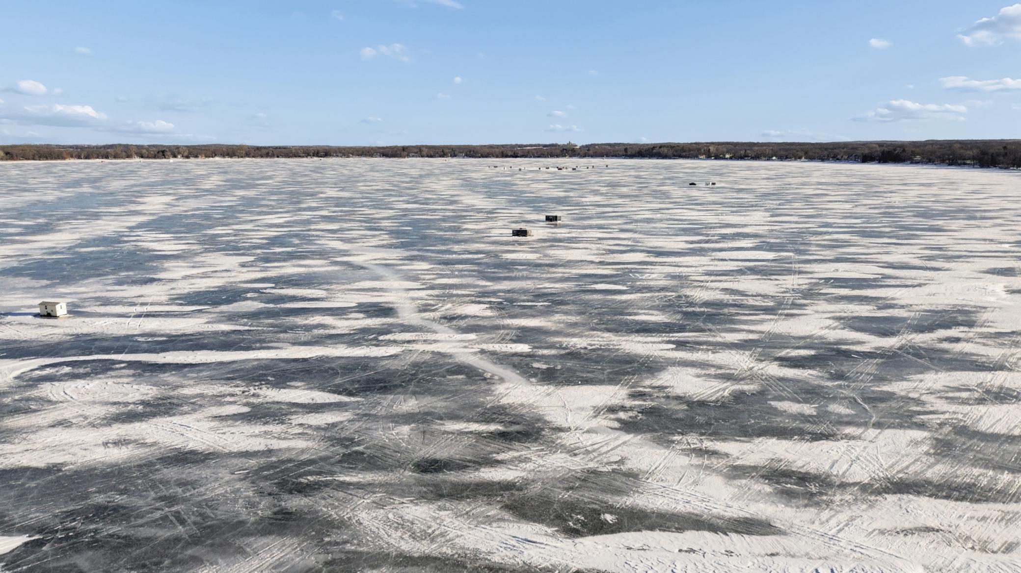 Aerial view of the frozen lake with ice houses.
