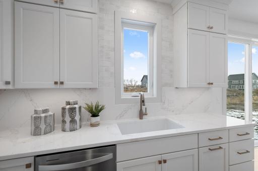 ELITE kitchen + prep kitchen with floor to ceiling cabinetry, double ovens, gas range, built-in hood vent, quartz countertops extended up backsplash, 2 sinks, upgraded appliances