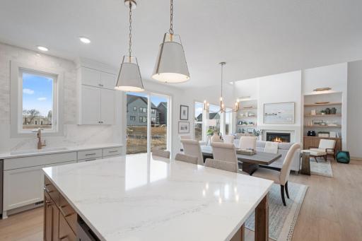 ELITE kitchen + prep kitchen with floor to ceiling cabinetry, double ovens, gas range, built-in hood vent, quartz countertops extended up backsplash, 2 sinks, upgraded appliances