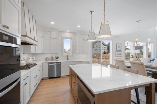 ELITE kitchen + prep kitchen with floor to ceiling cabinetry, double ovens, gas range, built-in hood vent, quartz countertops extended up backsplash, 2 sinks, upgraded appliances