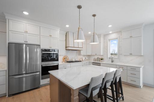 ELITE kitchen + prep kitchen with floor to ceiling cabinetry, double ovens, gas range, built-in hood vent, quartz countertops extended up backsplash, 2 sinks, upgraded appliances