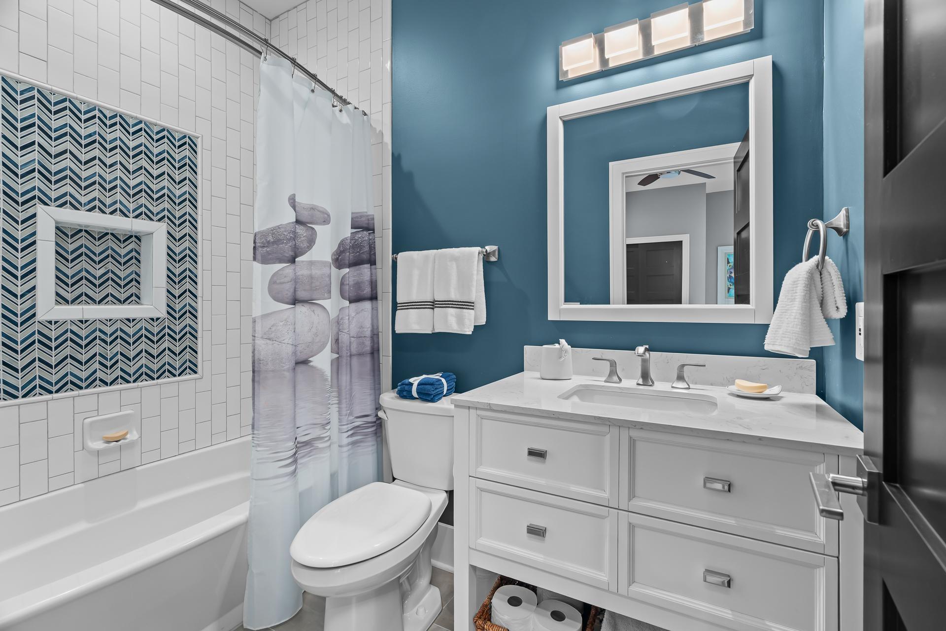 Full bathroom in 2nd bedroom ensuite with custom tile surround and floor.