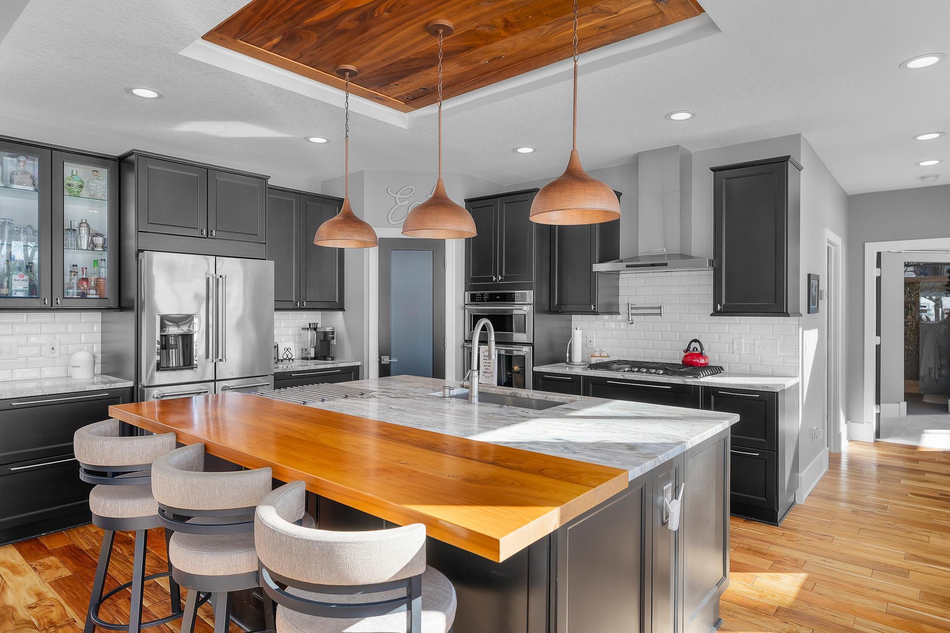 The custom gourmet kitchen features a center island with seating for 3-4.