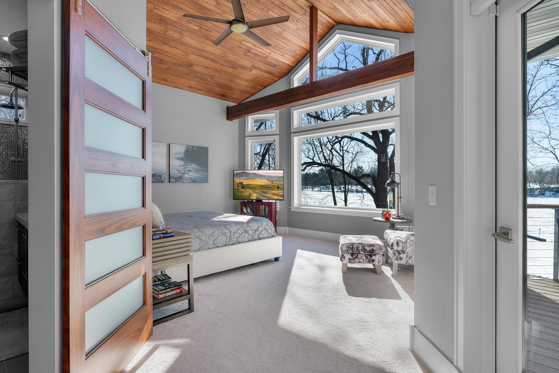The 17x14 primary bedroom suite is located down the hall from the main living area. Locally sourced custom poplar ceiling and beam. Private access to the deck and hot tub.