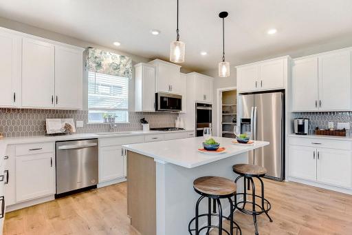 Wow, talk about natural light in this home! This kitchen features quartz kitchen countertops, a walk-in pantry, signature kitchen with double ovens and a gas cooktop, stainless appliances and more!