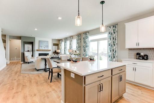Soaring windows provide an abundance of natural light to flow throughout the main level, including this nicely sized family room, featuring a natural gas fireplace.