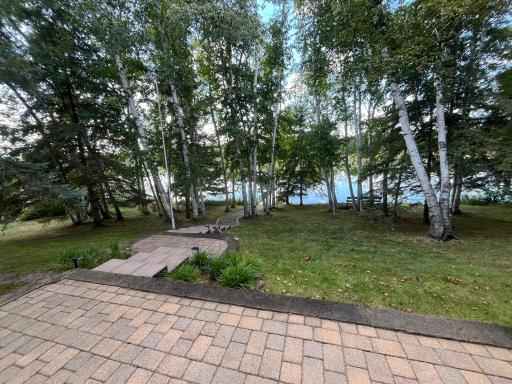Lakeside paver patio and gradual landscaped walkway/path to 143' shoreline and sandy swimming area!
