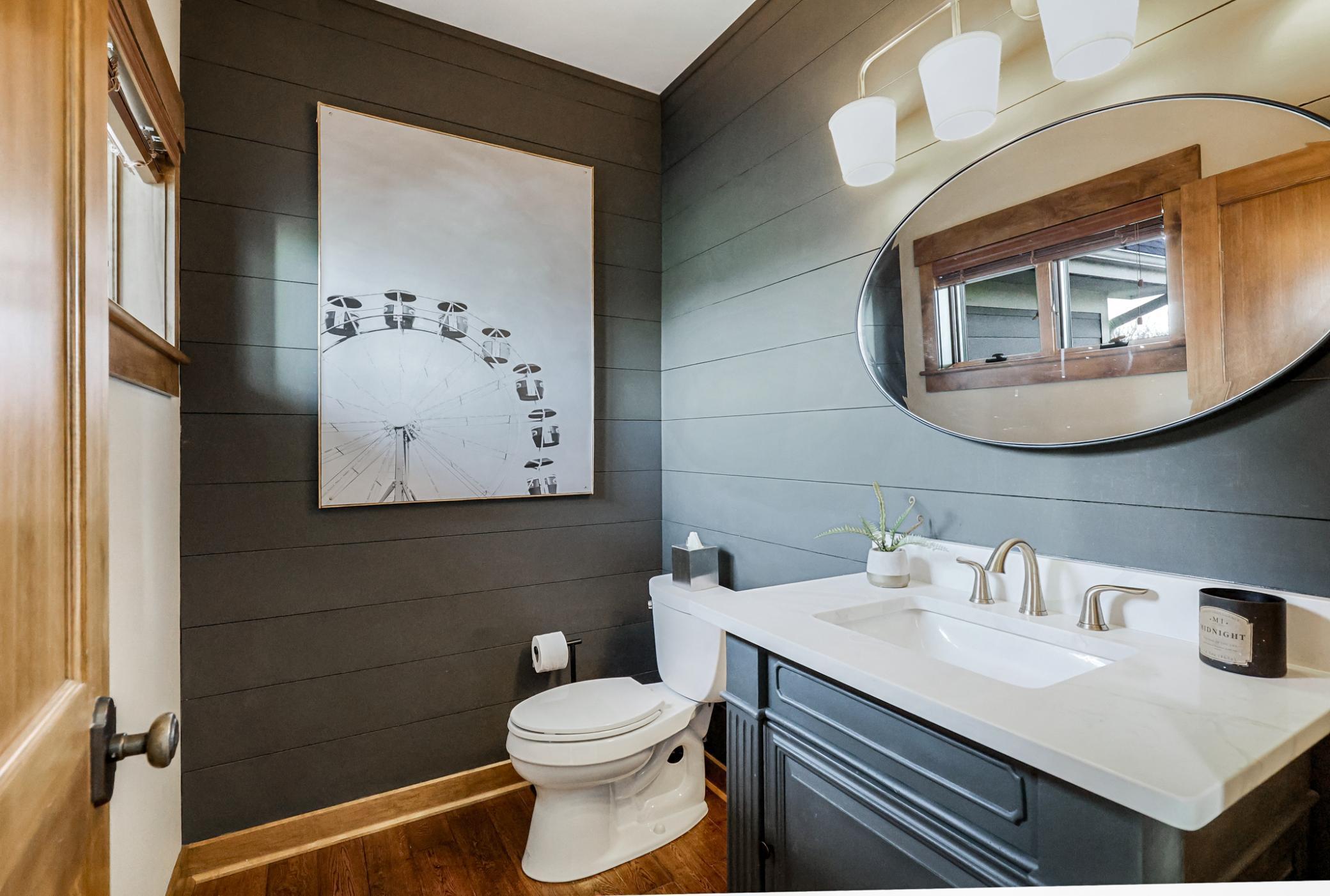 Powder bath (remodeled in 2019) with shiplap walls and quartz countertop.