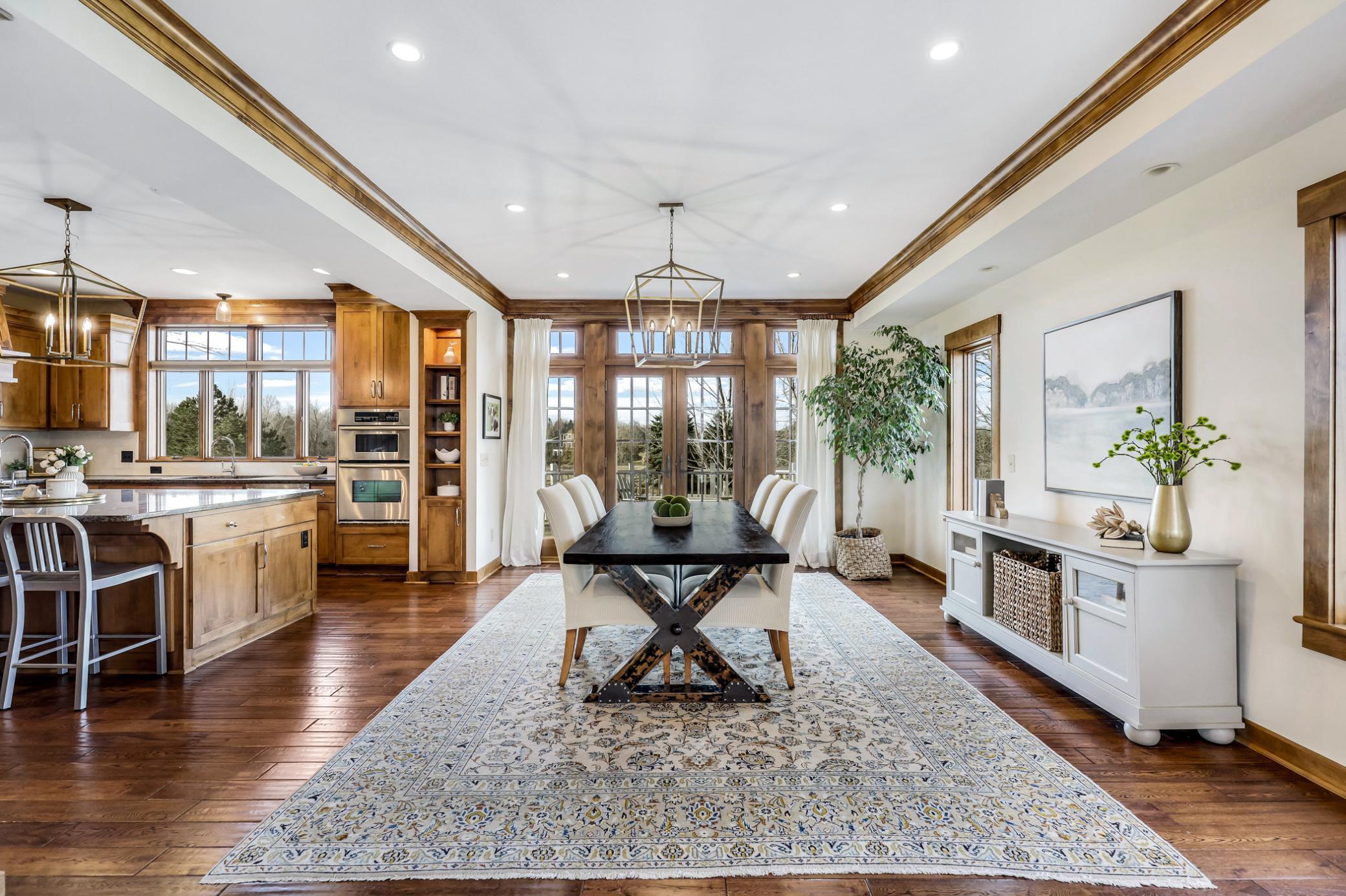 Walk-out access to the large, curved stamped concrete patio via glass French doors in front of home.