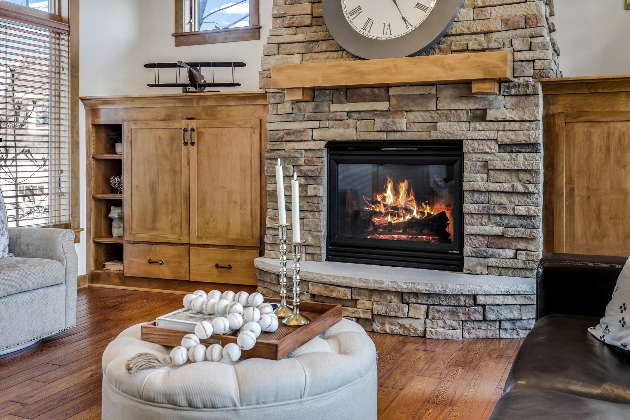 Cozy stacked stone gas fireplace.