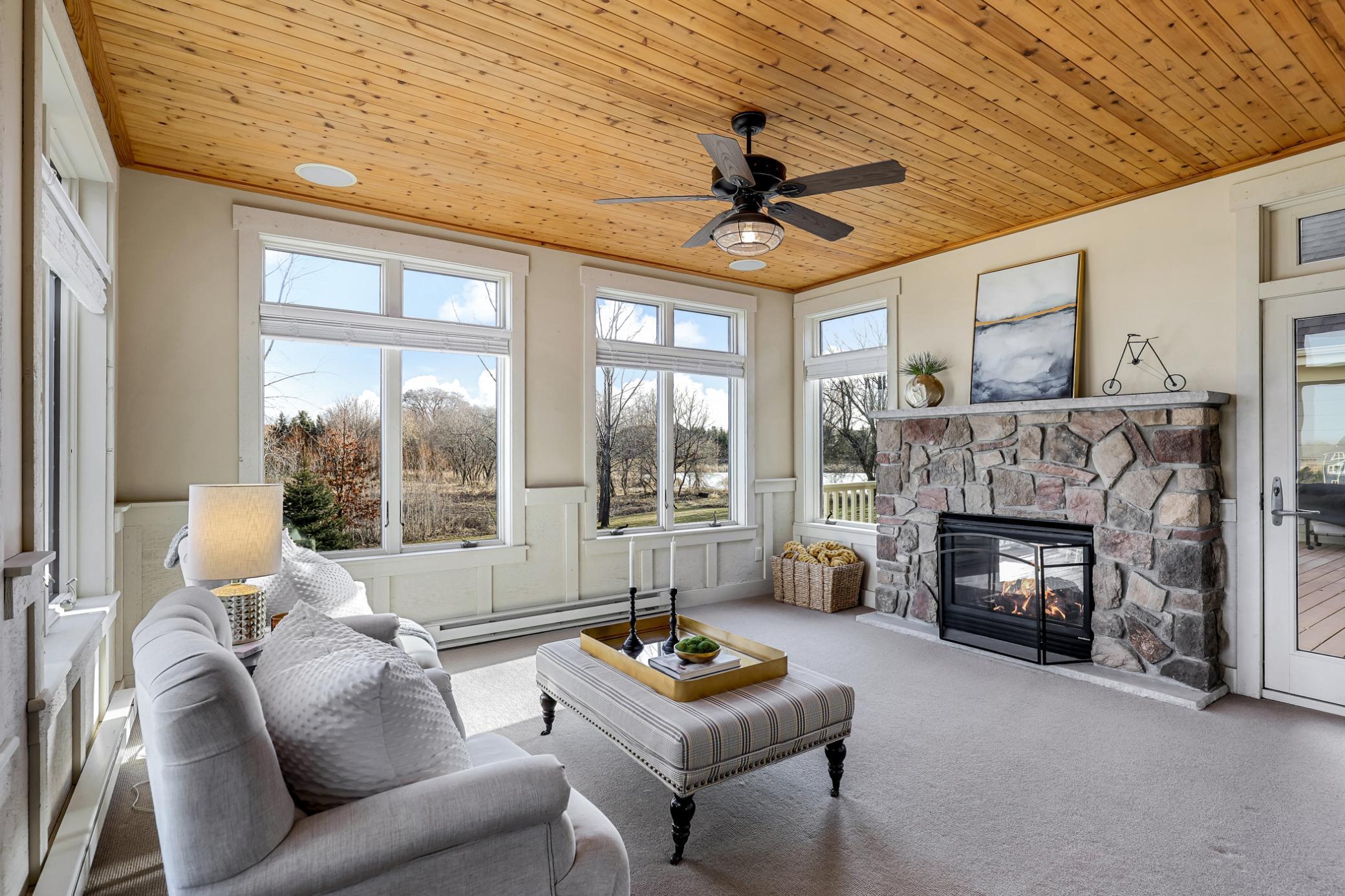 A comfortable space surrounded by screens/windows for tranquil backyard views + doors leading to both the deck and the great room. Wainscoted wall accents & knotty wood plank ceiling w/ceiling fan.