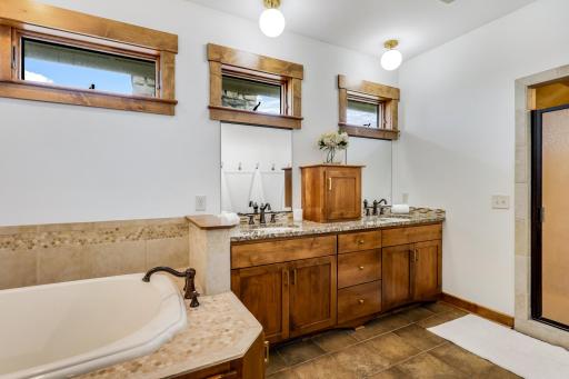 Large vanity with dual sinks and granite countertops + a soaking tub.