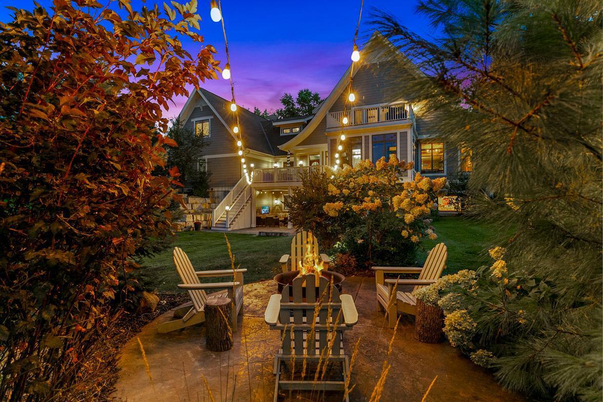 Circular stamped concrete patio set in the rear corner of the backyard is protected by evergreens and bushes making it perfect for a cozy fire-pit area.