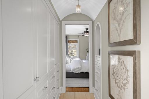 A barrel-vaulted hallway with built-ins leads to the Primary bath