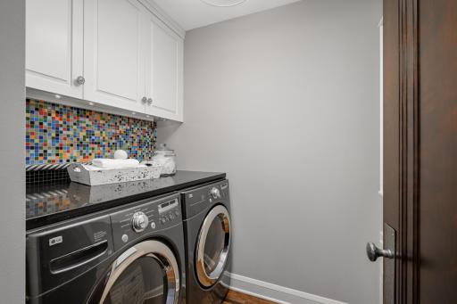 A 2nd floor full-sized laundry room with 2 clothes hampers and drying rack
