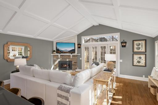 The main floor family room has a vaulted batten board ceiling, wood floors and a gas insert fireplace.