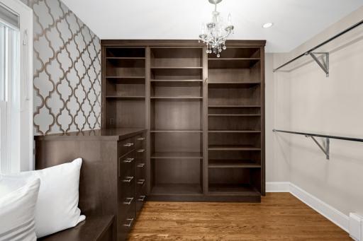 A huge walk-in primary closet with custom organizers
