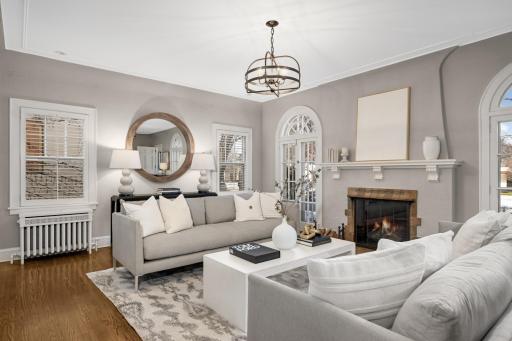 The grand sized living room has a fireplace, coved ceilings and French windows with arched transoms.