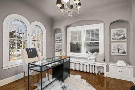 The secluded in-home office has arched windows and original niches.