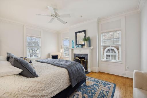 Spacious primary bedroom with a wood fireplace